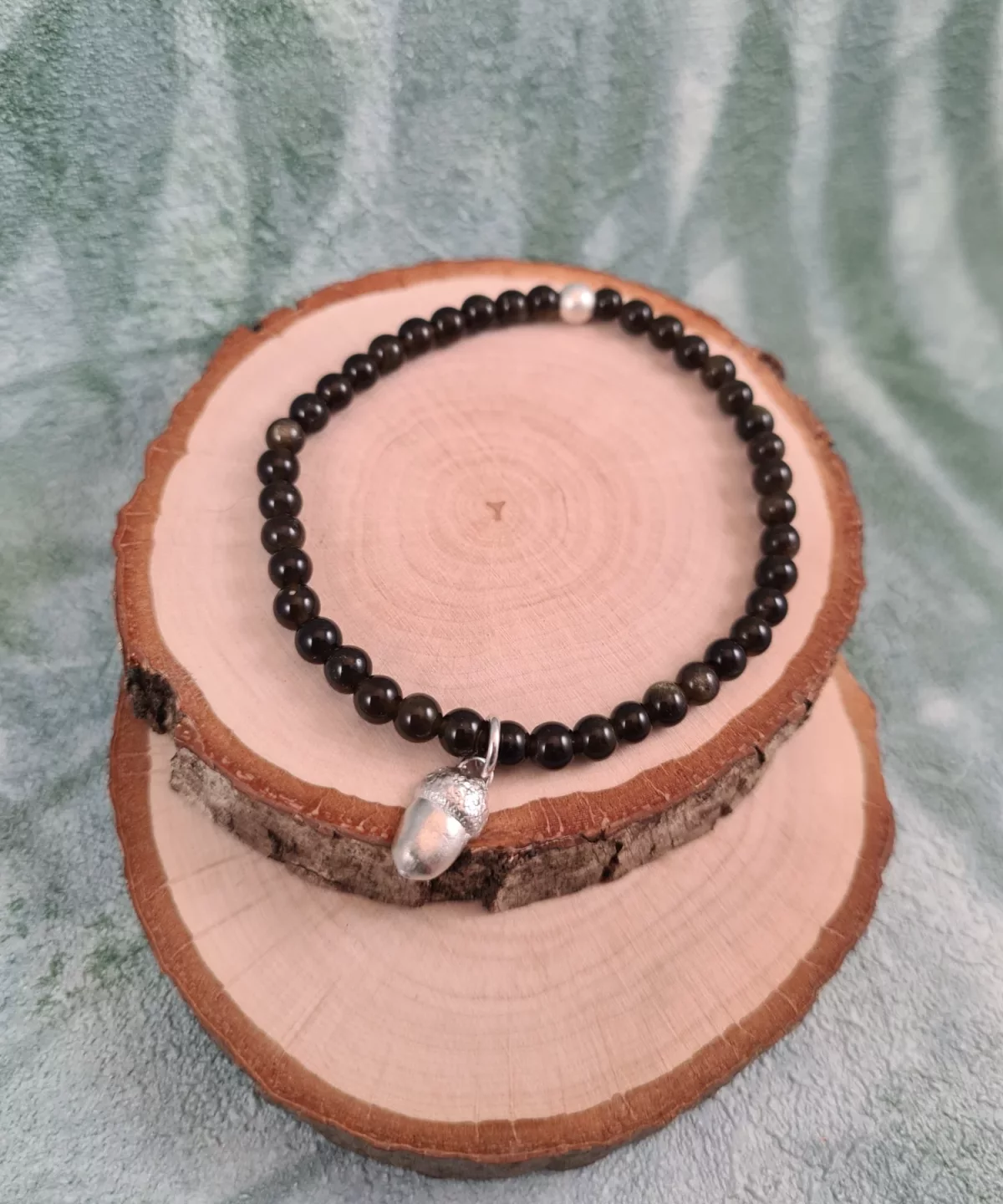 Bracelet charm gland et perles d'obsidienne dorée
